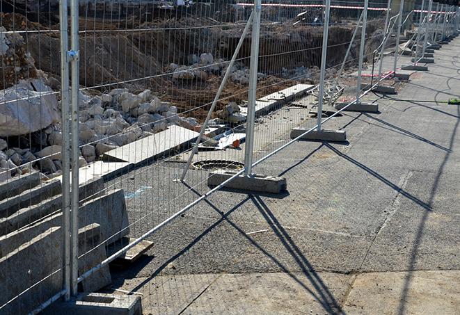 construction workers assembling temporary fence panels for safety